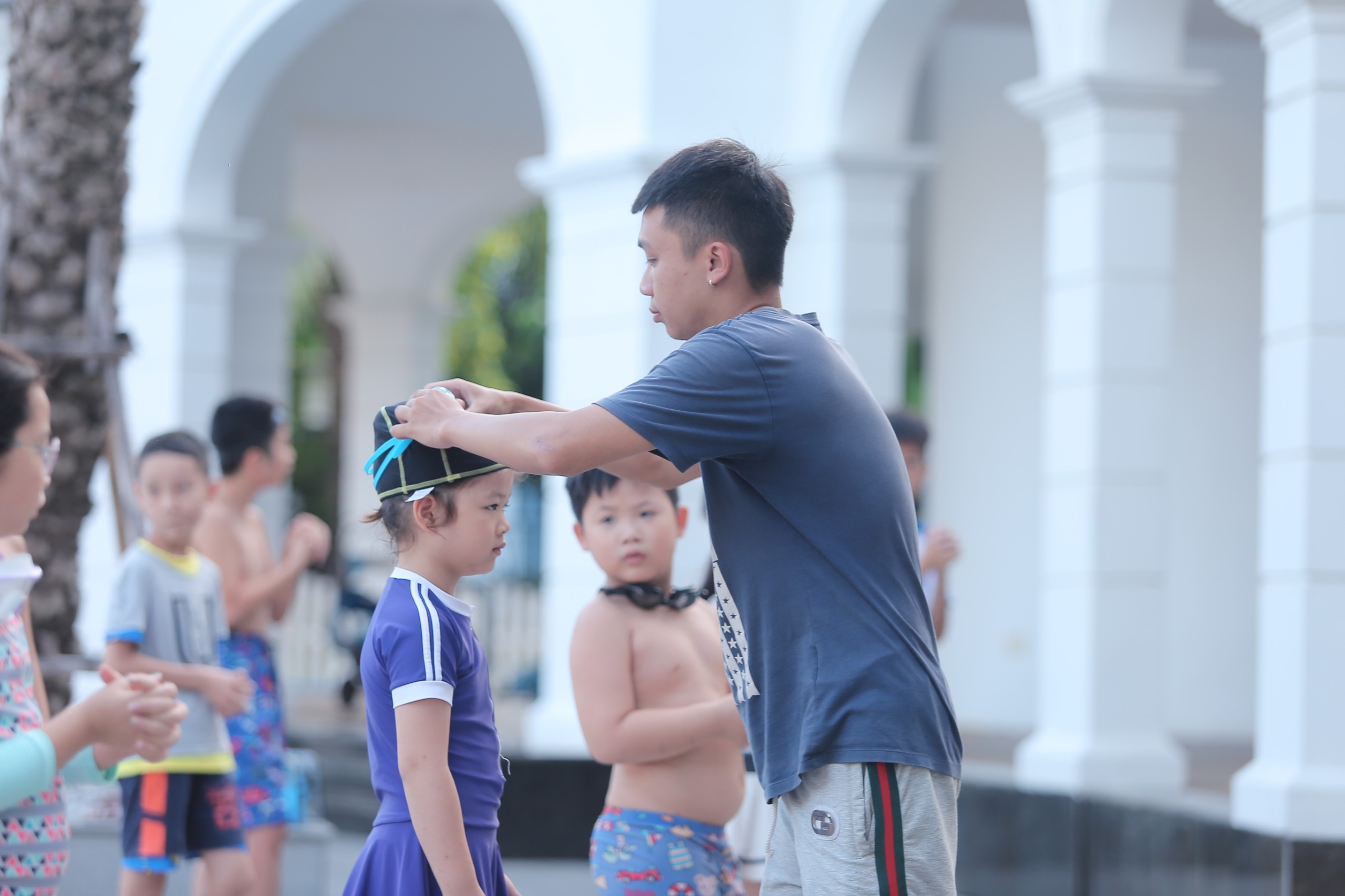 Đội ngũ giáo viên dạy bơi tận tâm của Swim For Life - HLV hỗ trợ học viên từng động tác trong bể bơi