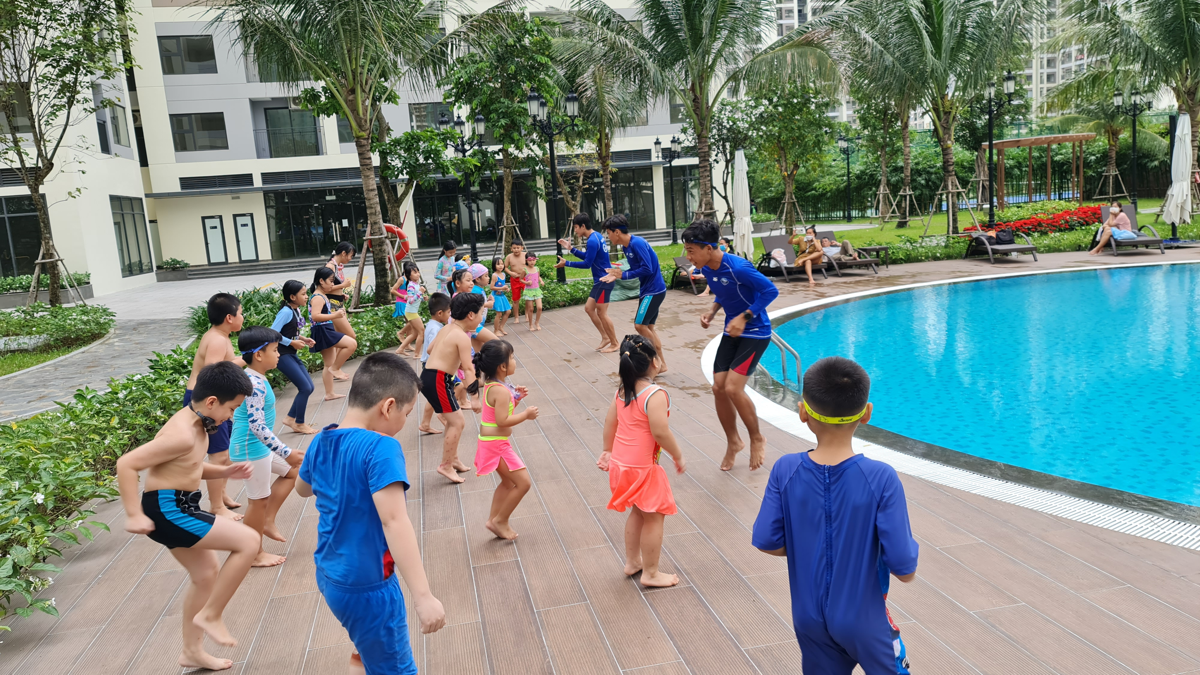 Các bé khởi động làm nóng cơ thể trước khi xuống bể